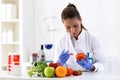 Scientist putting new sample to vegetables and cheking results Royalty Free Stock Photo