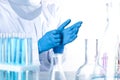 Scientist putting on protective gloves in chemistry laboratory