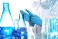 Scientist putting on protective gloves in laboratory. Solution chemistry