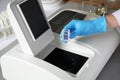 Scientist putting sample compartment with liquid in spectrophotometer. Laboratory analysis