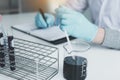 Scientist recording making note on book with his findings test tube in lab Royalty Free Stock Photo