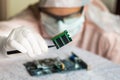 Scientist repairs electronic circuit and holding damaged electri Royalty Free Stock Photo