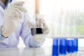 scientist stirs reagents beaker