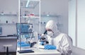 Scientist studying new virus in laborator using microscope