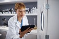 Scientist, tablet and serious woman with incubator in laboratory, research or online study. Technology, medical