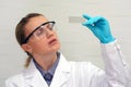 Scientist with a test glass working at the laboratory. Life scientist researching in laboratory. Female biochemist mixing