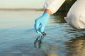 Scientist with test tube taking sample from river for analysis, closeup Royalty Free Stock Photo