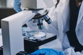 Scientist using microscope in laboratory. Close-up of a researcher& x27;s hands adjusting microscope in lab setting. Scienc Royalty Free Stock Photo