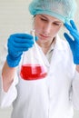 Scientist woman with equipment and laboratory glassware holding chemical liquid and checking result using as science research Royalty Free Stock Photo