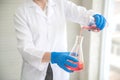Scientist woman with equipment and laboratory glassware holding chemical liquid and checking result using as science research Royalty Free Stock Photo