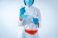 Scientist woman holding medical glass bottle with liquid, making laboratory research Royalty Free Stock Photo