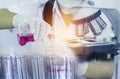 Scientist woman research carrying chemistry liquid with microscope equipment for research experiments to test tube