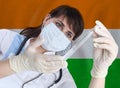 Scientist woman with test tube Coronavirus or COVID-19 against India flag. Research of viruses in laboratory Royalty Free Stock Photo