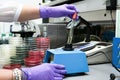 Scientist at work holding a tube in the machine fluid mixer in t