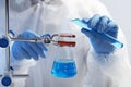 Scientist working with beaker and test tube on grey background, closeup Royalty Free Stock Photo