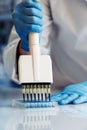 Scientist working with multichannel pipette and multi well plates Royalty Free Stock Photo