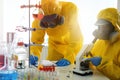 Scientists in chemical protective suits working. Virus research