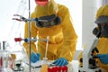 Scientists in chemical protective suits working. Virus research
