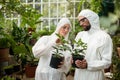 Scientists in clean suit examining potted plants Royalty Free Stock Photo