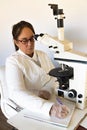 scientist writing next to the microscope Royalty Free Stock Photo