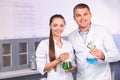 Scientists holding test flasks with samples in laboratory