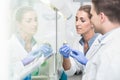 Scientists in laboratory preparing samples under splashback Royalty Free Stock Photo