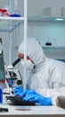 Scientists in protection suits working in chemical lab