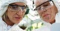 Scientists in protective gear analyzing data on transparent screen in laboratory