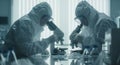 Scientists in protective gear using microscopes in laboratory for research and analysis