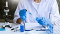Scientists researching in laboratory in white lab coat, gloves analysing, looking at test tubes sample, biotechnology concept Royalty Free Stock Photo