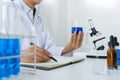 Scientists researching in laboratory in white lab coat, gloves analysing, looking at test tubes sample, biotechnology concept Royalty Free Stock Photo