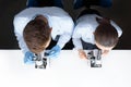 Scientists in uniforms looking through microscopes in laboratory Royalty Free Stock Photo