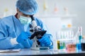 Scientists wear protective clothing looking for microscopes while doing medical research in a science laboratory