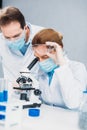 scientists in white coats medical gloves and goggles making scientific research together Royalty Free Stock Photo