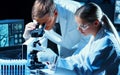 Scientists working in modern lab. Doctor making microbiology research. Laboratory tools: microscope, test tubes