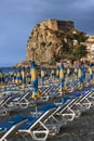 View of beach lounge deck and ancient Ruffo Castle. Italy, Scilla