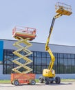 Scissor and articulated boom wheeled lifts on asphalt ground Royalty Free Stock Photo