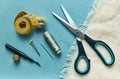 Scissor, measure, thread, thimble and pins on blue background Royalty Free Stock Photo