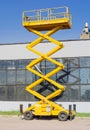 Scissor self propelled lift on the background of industrial building