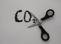 A scissor on a sheet of a paper cuts an inscription, CO2. Carbon dioxide reduction concept