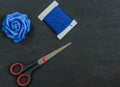 Scissor, thread and blue rose.