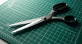Scissors with black handles rest on a green cutting mat featuring a grid and ruler Royalty Free Stock Photo