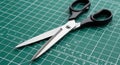 Scissors with black plastic handles rest on a green cutting mat marked with a grid for Royalty Free Stock Photo