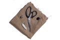 Scissors, button, spool of thread and a needle on sackcloth Royalty Free Stock Photo