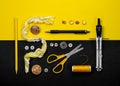 Scissors, buttons, zipper, thread and thimble on yellow and black Royalty Free Stock Photo