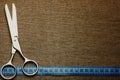 Scissors, centimeter tape and fabric background. Concept - sewing business, fabric business, sewing workshop