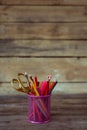 Scissors and colorful pencils of violet yellow pink red and orange in stationary cup on wooden table and background Royalty Free Stock Photo