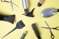 Scissors, comb and other hair styling tools on yellow background Royalty Free Stock Photo