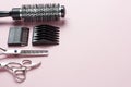 Scissors and comb on a pink background, copy space Royalty Free Stock Photo