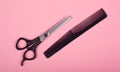 Scissors and comb on a pink background, hairdressing concept.barber tools Royalty Free Stock Photo